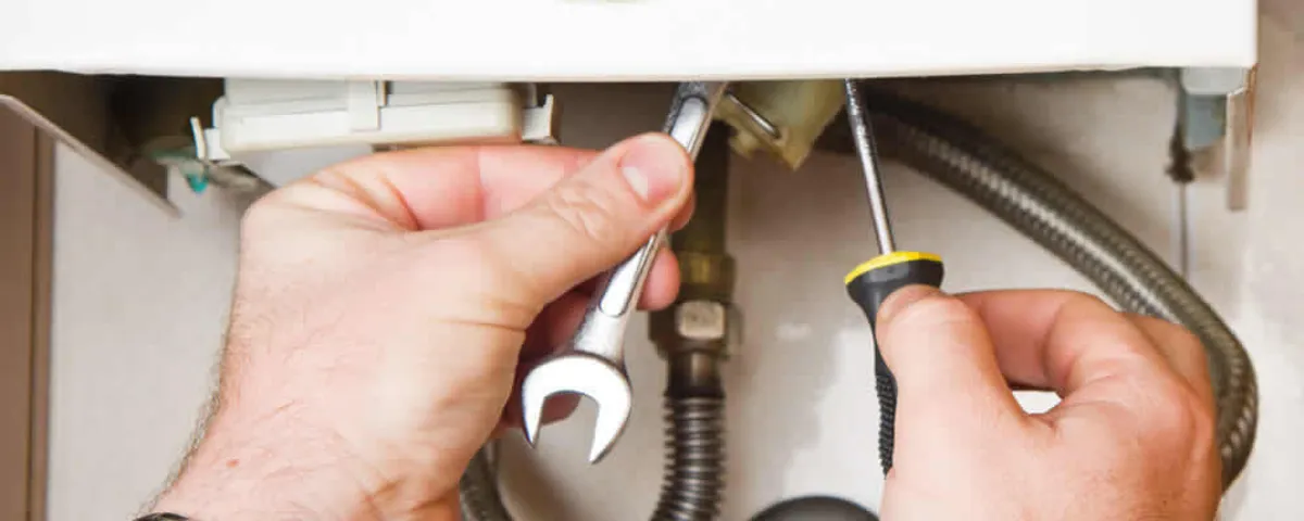 Boiler repair technician tightening pipe fittings and connections in Tampa, FL