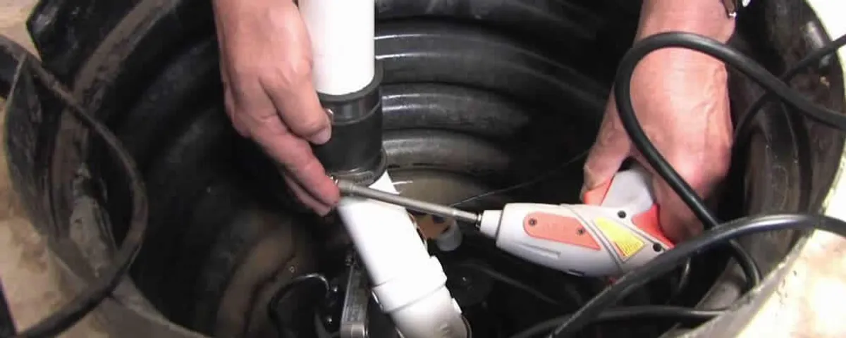 Sump pump installation technician connecting PVC discharge piping in Tampa, FL